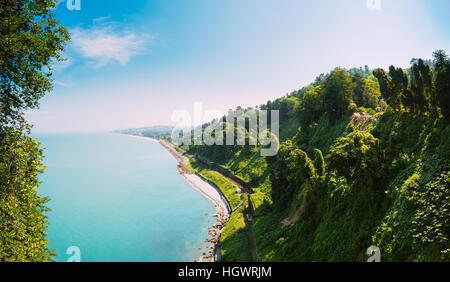 Schönen Sommer Panoramablick vom Botanischen Garten der Meeresbucht und Eisenbahn an Küste. Die üppige grüne Vegetation des Sommers. Sonniger Tag. Batumi, Adscharien Ge Stockfoto