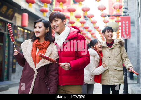 Junge Freunde mit kandierten Haw Beeren feiert Chinesisches Neujahr Stockfoto