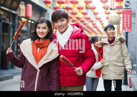 Junge Freunde mit kandierten Haw Beeren feiert Chinesisches Neujahr Stockfoto