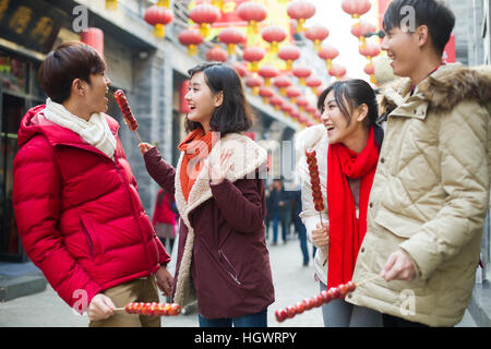 Junge Freunde mit kandierten Haw Beeren feiert Chinesisches Neujahr Stockfoto