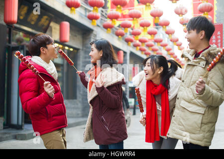 Junge Freunde mit kandierten Haw Beeren feiert Chinesisches Neujahr Stockfoto