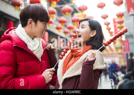 Junges Paar mit kandierten Haw Beeren feiert Chinesisches Neujahr Stockfoto