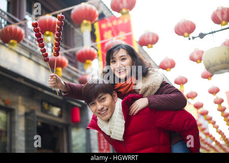 Junges Paar mit kandierten Haw Beeren feiert Chinesisches Neujahr Stockfoto