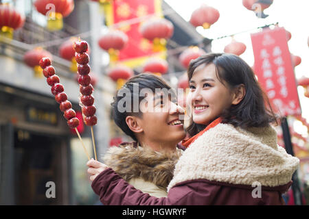 Junges Paar mit kandierten Haw Beeren feiert Chinesisches Neujahr Stockfoto