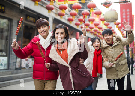 Junge Freunde mit kandierten Haw Beeren feiert Chinesisches Neujahr Stockfoto