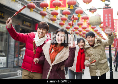 Junge Freunde mit kandierten Haw Beeren feiert Chinesisches Neujahr Stockfoto