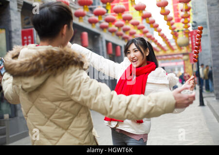 Junges Paar mit kandierten Haw Beeren feiert Chinesisches Neujahr Stockfoto