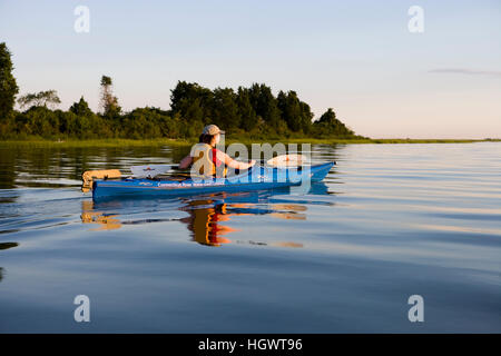 Eine Frau Kajaks im Fluss schwarz Hall in der Nähe der Mündung des Connecticut River in Old Lyme, Connecticut. Stockfoto