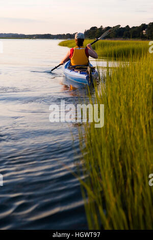 Eine Frau Kajaks in einem sumpfigen Teil des Connecticut River in Old Lyme, Connecticut.  In der Nähe von Great Island und der Mündung des Flusses. Stockfoto