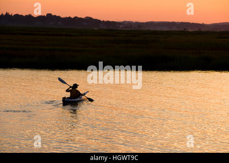 Eine Frau Kajaks bei Sonnenuntergang in den Connecticut River in Old Lyme, Connecticut. Stockfoto