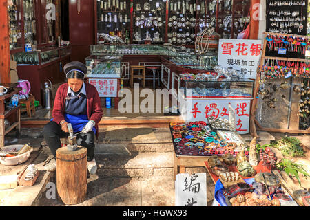 Lijiang, China - 14. November 2016: Young Naxi Mann arbeitet in seiner Werkstatt in der Altstadt von Lijiang Stockfoto