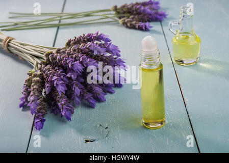 Bundle aus Lavendelblüten und ätherisches Öl auf Vintage Holz-Hintergrund Stockfoto