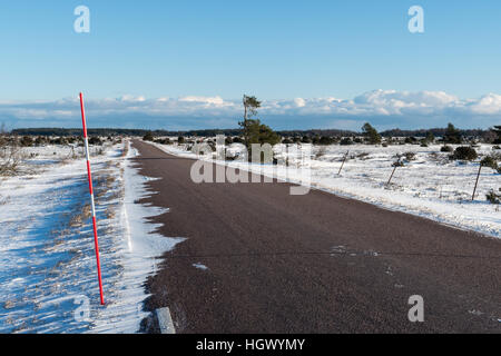 Schnee geht durch eine verschneite Land Straßenseite durch die Tiefebene Alvar Gegend auf der schwedischen Insel Öland Stockfoto