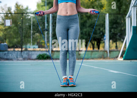 Frau in Sportbekleidung Training mit Springseil auf dem Stadion Stockfoto