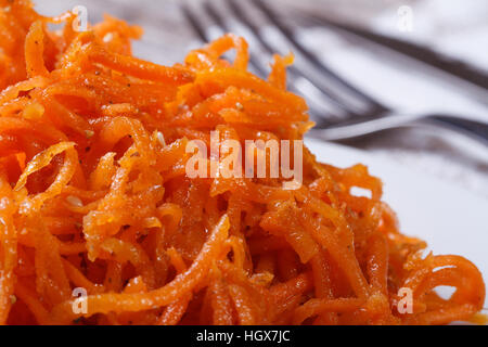 geriebene Karotten mit Gewürzen auf weißen Teller closeup Stockfoto