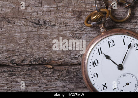 alte Taschenuhr an einer Kette auf einem alten Holztisch closeup Stockfoto