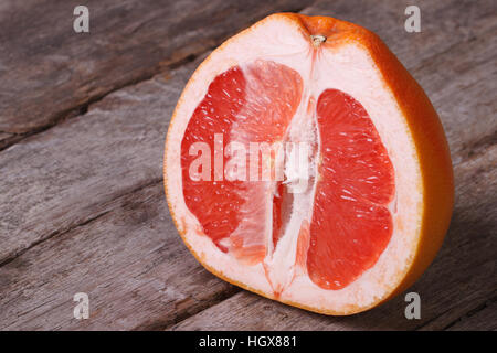 In Scheiben geschnitten Reife Grapefruit auf einem alten Holztisch closeup Stockfoto