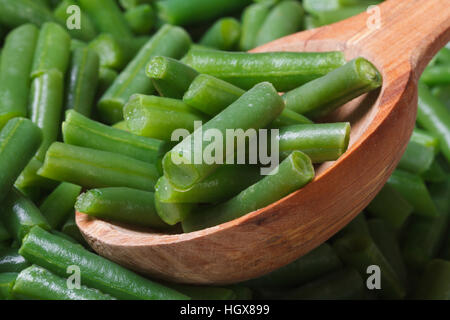 gehackte grüne Bohnen Closeup auf Holzlöffel. Hintergrund. Makro Stockfoto