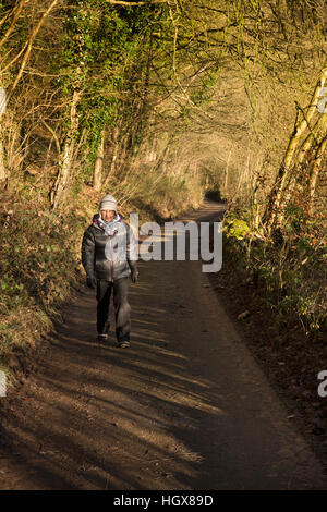 Großbritannien, England, Derbyshire, Cressbrook, senior weiblichen Walker auf der Lane Ravensdale Cottages im winter Stockfoto