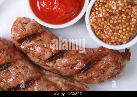 zwei gegrillte heiße Würstchen mit Ketchup und Dijon-Senf. Closeup. Ansicht von oben Stockfoto