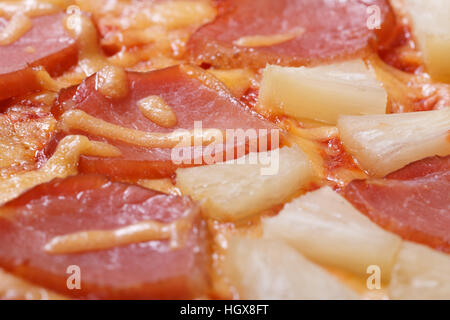 Pizza Hawaii mit Ananas und Schinken Hintergrund Makro Textur. Nahaufnahme Stockfoto