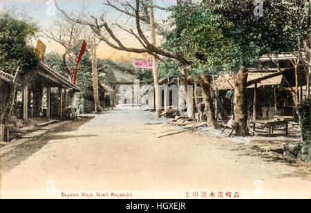 Japan, Nagasaki. Alte Ansichtskarte Hand gefärbt. Straße mit heruntergekommenen Hütten auf beiden Seiten, einige Geschäfte. Auf dem Lande suchen. Stockfoto