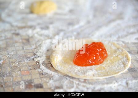 Aprikose Marmelade auf den Teig für die Zubereitung von Kuchen Stockfoto