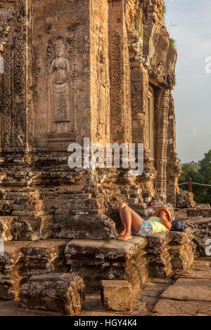 Müden Touristen ruht auf einem Tempel im späten Nachmittag, die untergehende Sonne am Pre Rup, Siem Reap, Angkor, Kambodscha. Stockfoto