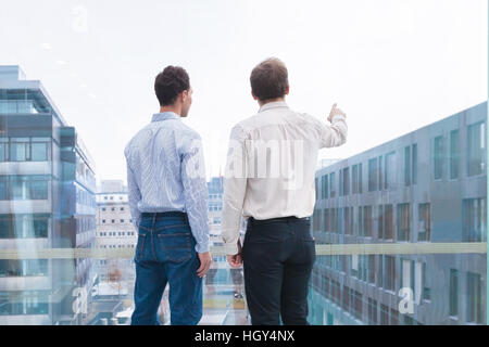 Zwei Geschäftsleute sprechen und Blick auf den Horizont, eine Person, die auf etwas zeigen. Konzept über Projekte, Visionen, Möglichkeiten Stockfoto