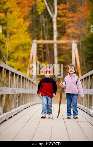 Ein junger Bruder und Schwester (4 und 6 Jahre alt) Wanderung auf einer Hängebrücke in New Hampshire White Mountain National Forest.  Lincoln Woods Trail. Stockfoto