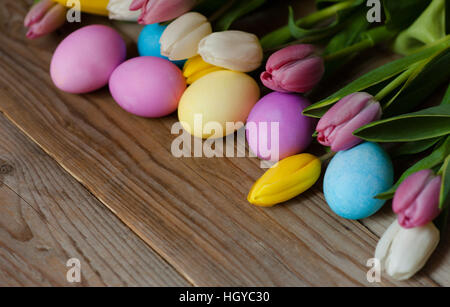 Ostereier und farbigen Tulpen Blumen auf hölzernen Hintergrund Stockfoto