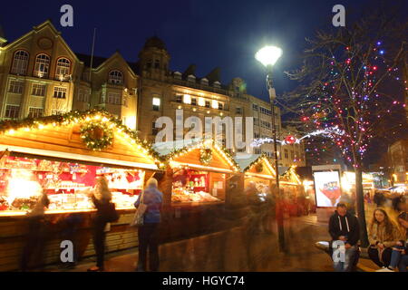 Festliche Shopper durchsuchen waren in niedlichen Holzhütten auf dem Weihnachtsmarkt am Fargate Sheffield Stadtzentrum Yorkshire, England Stockfoto