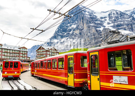 Berg-Eisenbahnen auf kleinen Scheidegg oberhalb Grindelwald Schweiz mit dem Eiger hinter Stockfoto