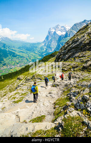 Wanderer auf den Eiger Trail Schweiz mit das Tal von Grindelwald und Wetterhorn Peak hinter Stockfoto