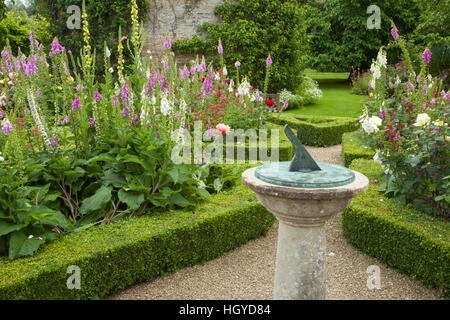 Dekorative Sonnenuhr und Box Hecke Grenzen bepflanzt mit Rosen und Fingerhut innerhalb der ummauerten Garten Rousham House in Oxfordshire, England. Stockfoto