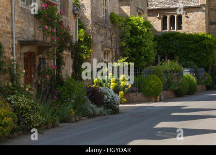 Cotswold Steinhütten mit bunten am Straßenrand floralen Grenzen in dem Dorf Stanton, Cotswolds, Gloucestershire, England Stockfoto