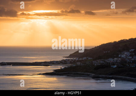 Lyme Regis, Dorset, UK. 13. Januar 2017. Großbritannien Wetter. Dramatische Sonnenstrahlen über den Badeort Lyme Regis während des Sonnenuntergangs an der Küste von Dorset Jurassic aus betrachtet die Klippen von Charmouth. Bild © Graham Hunt/Alamy Live-Nachrichten Stockfoto