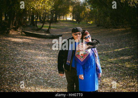 Erwachsene Paare, die im Herbst Park. Mann und Frau zu Fuß im Freien im Herbst letzten Tage, Mann mit einem Schnurrbart tragen Sonnenbrillen Stockfoto