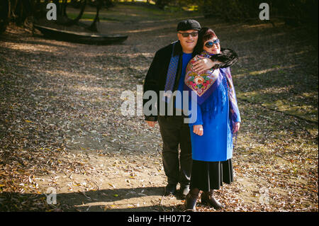 Erwachsene Paare, die im Herbst Park. Mann und Frau zu Fuß im Freien im Herbst letzten Tage, Mann mit einem Schnurrbart tragen Sonnenbrillen Stockfoto