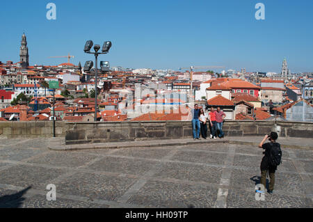 Porto, Portugal, Europa: ein Mann, der eine Gruppe von Touristen mit den roten Dächern, die Skyline und die Torre dos Clerigos auf dem Hintergrund Stockfoto