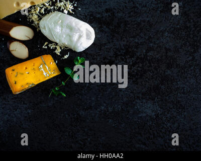 Frische Stücke Käse (Mozzarella, Roquefort, Maasdam) auf den steinernen Tisch Stockfoto