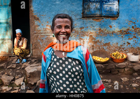 Frau außerhalb eines der ältesten Häuser in der Stadt Gondar, Äthiopien. Gondar Kaiserstadt voller Burgen der alten Kaiser auch in eine Stockfoto