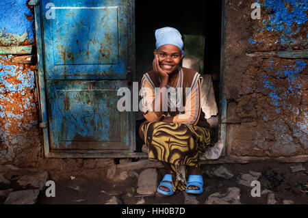 Frau außerhalb eines der ältesten Häuser in der Stadt Gondar, Äthiopien. Gondar Kaiserstadt voller Burgen der alten Kaiser auch in eine Stockfoto
