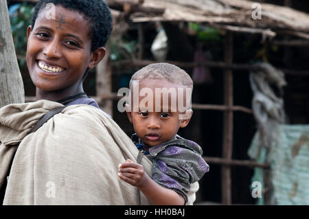 Hawzen Stadt, östlichen Tigray, Äthiopien. Äthiopische Mütter tragen ihre Kinder den ganzen Tag in dieser Art der Babytrage. Manchmal machen die einfachsten Dinge Stockfoto