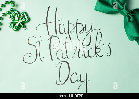 Happy St. Patrick-Tageskarte der Kalligraphie und grüne Zubehör Stockfoto