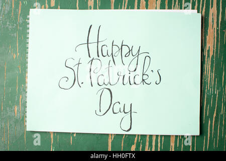 Happy St. Patrick Day Kalligraphie Karte auf grünem Papier Stockfoto