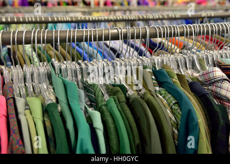 Rack mit bunten grünen Shirts für Verkauf im Shop Stockfoto