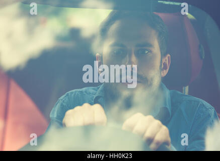 geschockt erschrocken lustig aussehende junge Fahrer im Auto. Menschliche Emotionen Gesichtsausdruck. Vordere Fenster mit Blick auf unerfahrene ängstlich Treiber-Konzept Stockfoto