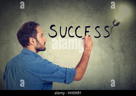 Seite Profil junger Mann Erfolg auf eine graue Wand zu schreiben Stockfoto