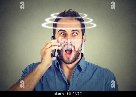 Kopf dreht Schwindel Schwindel. Porträt schockiert man telefonieren mit Handy. Schlechte Nachrichten. Moderne Geräte und Gesundheitsfragen Stockfoto